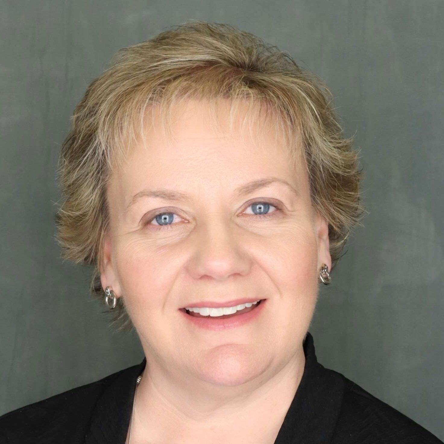 Headshot of Jeanne Jenkins smiling in a black blazer and blue shirt.