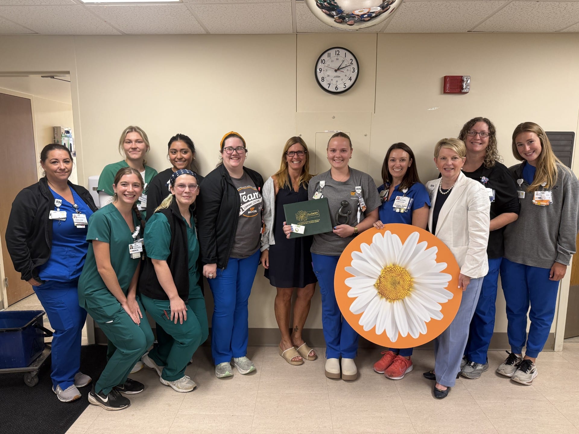 Anna Cherrie receiving DAISY award surrounded by other UTMC staff members